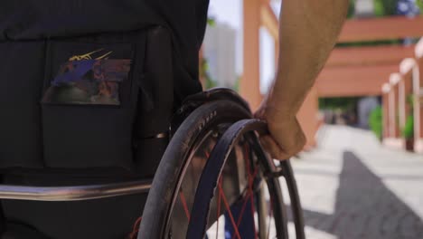 Close-up-of-disabled-young-man-using-wheelchair-in-slow-motion.